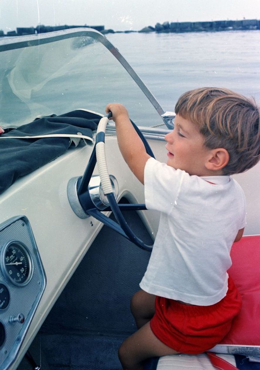 John Jr. takes the wheel of a speedboat during Labor Day weekend in 1963.