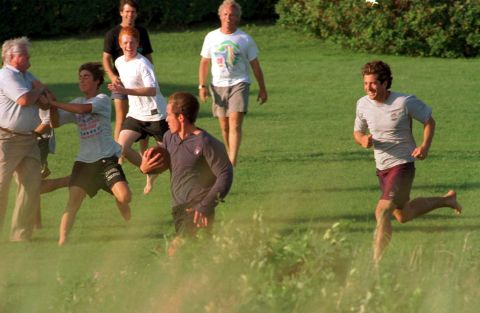 Ted Kennedy, left, and John Jr., right, join other family members for a football game in 1997.