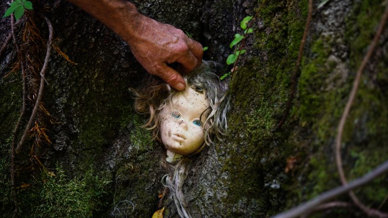 <strong>Upkeep outdoors:</strong> Slaton adjusts a doll's head as part of regular maintenance on the trail. Unfortunately, some really creative displays have been lost to vandals. But new ones take their place.