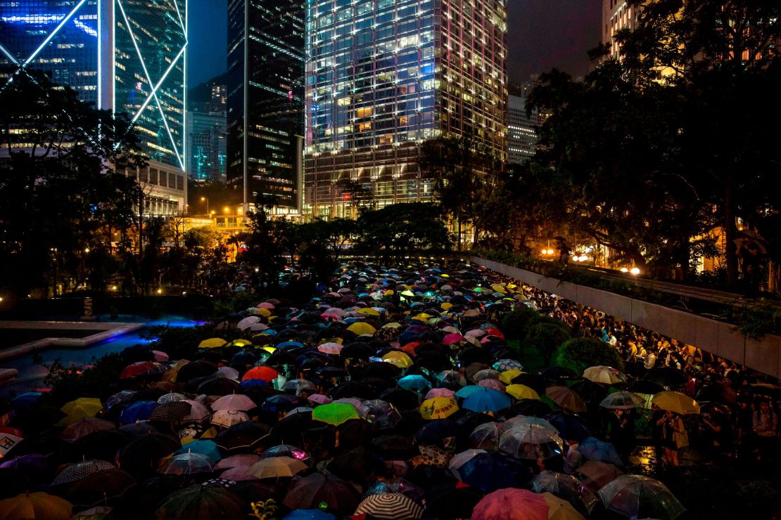 People from the finance community hold up umbrellas and shine lights during a protest against a controversial extradition bill in Hong Kong on August 1.