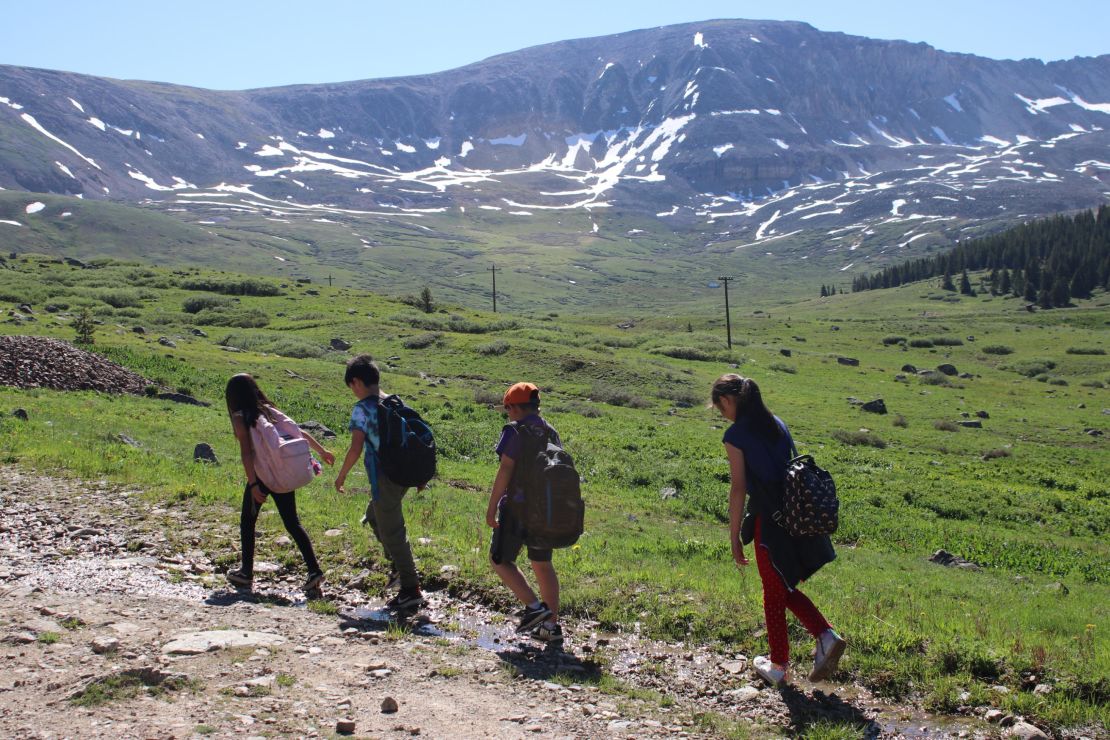 A group of 8- and 9-year-olds trudges up a mountain as part of a program through Get Outdoors Leadville! 