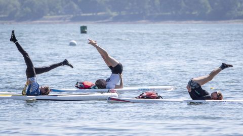 Paddleboard yoga, as seen here in a class in Maine, involves balancing on a paddleboard while doing yoga poses.