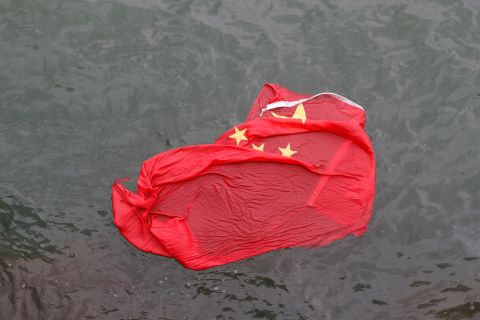 A Chinese flag floats in water after it was thrown by protesters during a demonstration on Saturday, August 3.