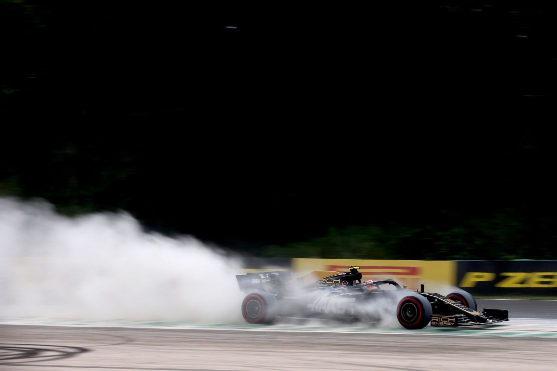 Kevin Magnussen drives through cement dust laid down by marshals.