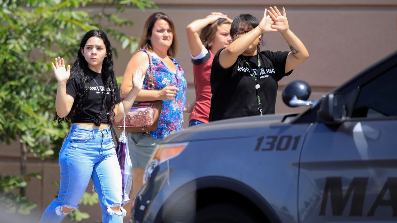 Shoppers exit with their hands up after a shooting in El Paso, Texas, on Saturday.