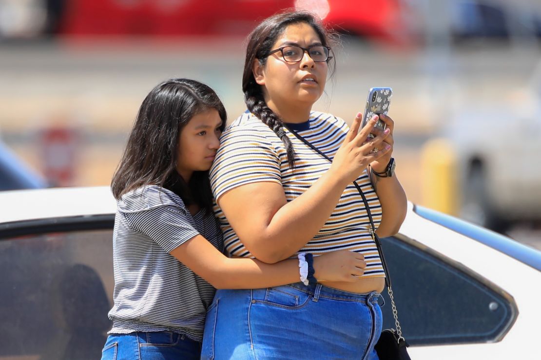 Girls stand outside the Walmart after the shooting.
