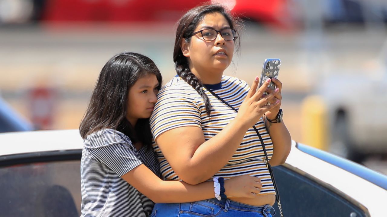 Girls stand outside the Walmart after the shooting.