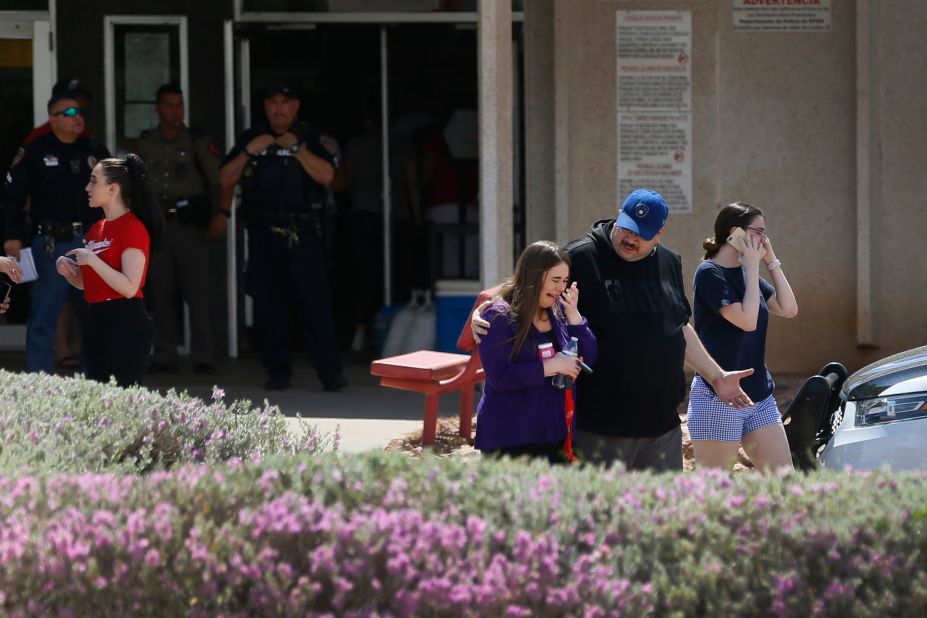 People gather at MacArthur Elementary School in El Paso, looking for family and friends. The school was being used as a reunification center.