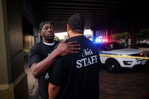 Witnesses comfort one another at the scene in Dayton on Sunday.