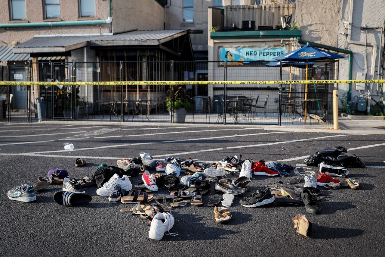 Shoes, hats and other items are piled together outside a bar in Dayton on Sunday.