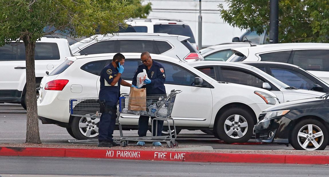 Police conduct their investigation in the parking lot of an El Paso Walmart on Sunday.