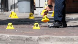 Authorities remove evidence markers at the scene of a mass shooting, Sunday, Aug. 4, 2019, in Dayton, Ohio. Multiple  people in Ohio have been killed in the second mass shooting in the U.S. in less than 24 hours, and the suspected shooter is also deceased, police said. (AP Photo/John Minchillo)