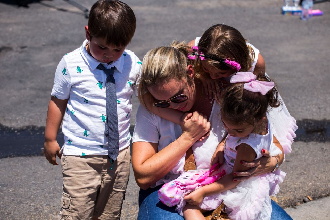 Cristina Zapata and her children pay their respects to the victims of the El Paso shooting.