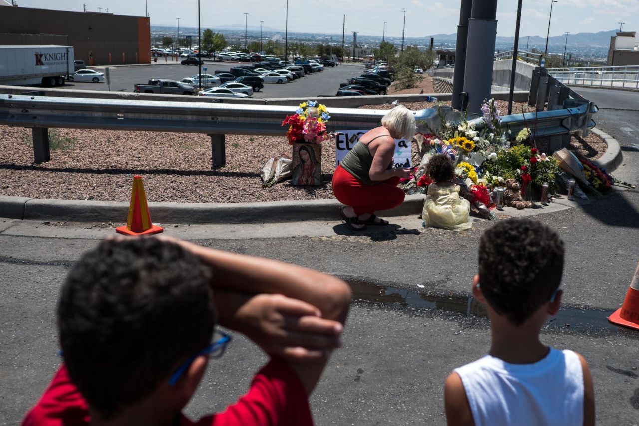 People pay their respects to the victims of the El Paso shooting at a makeshift memorial across from the Walmart near the Cielo Vista Mall.