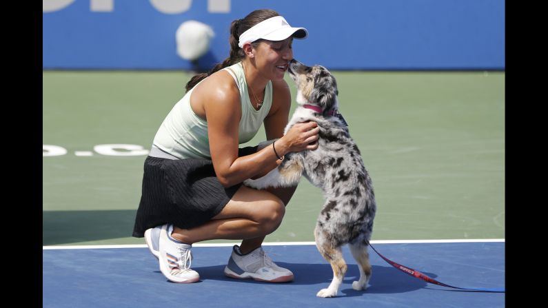 Jessica Pegula of the United States is greeted by her dog Maddie during the trophy presentation after her match against Camila Giorgi of Italy in the women's singles final in Washington, DC on Sunday, August 4. 