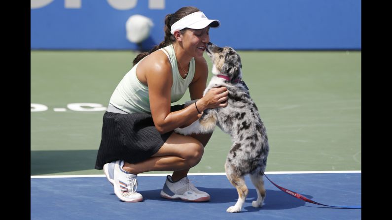 Jessica Pegula of the United States is greeted by her dog Maddie during the trophy presentation after her match against Camila Giorgi of Italy in the women's singles final in Washington, DC on Sunday, August 4.