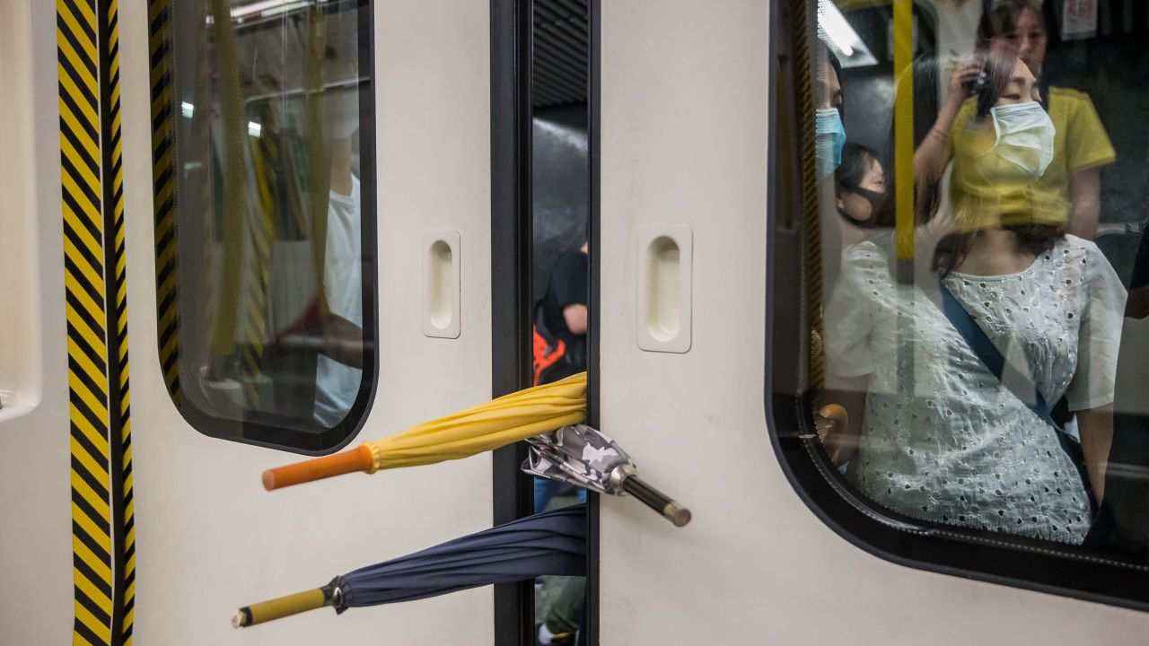 A group of protesters prevent the doors of a commuter train from closing on August 5.