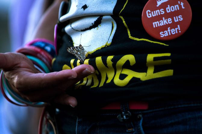 A butterfly grips onto Patricia Oliver during an El Paso vigil. Oliver's son, Joaquin, was killed in the Parkland, Florida, school shooting in 2018. Sunday would have been his 19th birthday.