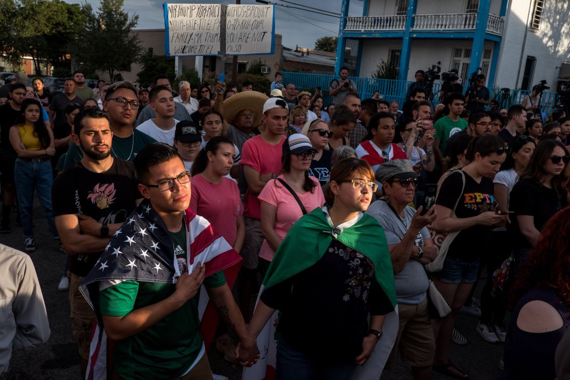 Cesar Antonio Pacheco, 24, left, and Samantha Ordaz, 20, both of El Paso, hold hands during a vigil.