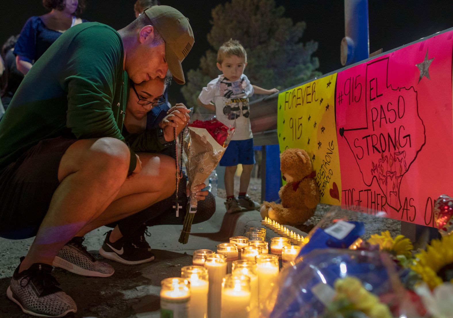 Mourners pray at a makeshift memorial for the victims of the El Paso shooting.