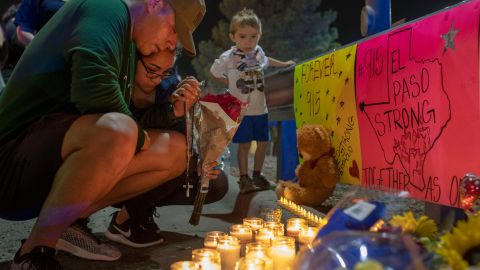 Rene Aguilar and Jackie Flores pray at a makeshift memorial for the victims of Saturday's mass shooting.