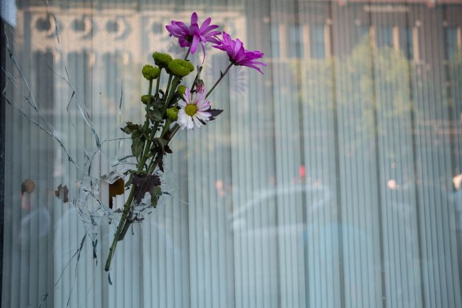 Flowers are placed in a bullet hole a few buildings away from where the shooting took place in Dayton.