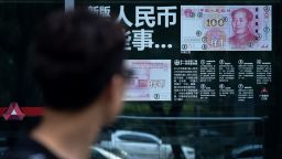 A man looks at information posted on a bank door showing how to distinguish real banknotes in Beijing on July 20, 2018. - China's yuan continued its steady decline on July 20, defying US President Donald Trump's warning over the dollar's rise and providing Beijing with a buffer against punitive trade tariffs imposed by Washington. (Photo by WANG ZHAO / AFP)        (Photo credit should read WANG ZHAO/AFP/Getty Images)
