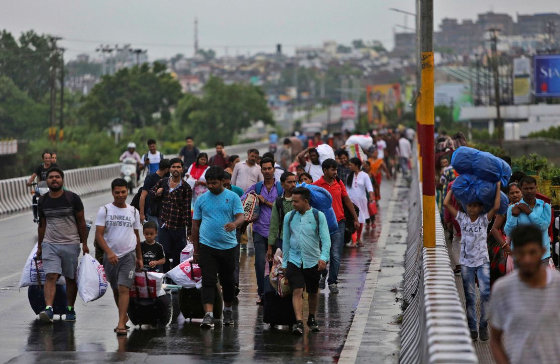 Stranded Indian tourists walk to a railway station during restrictions in Jammu on August 5, 2019. 