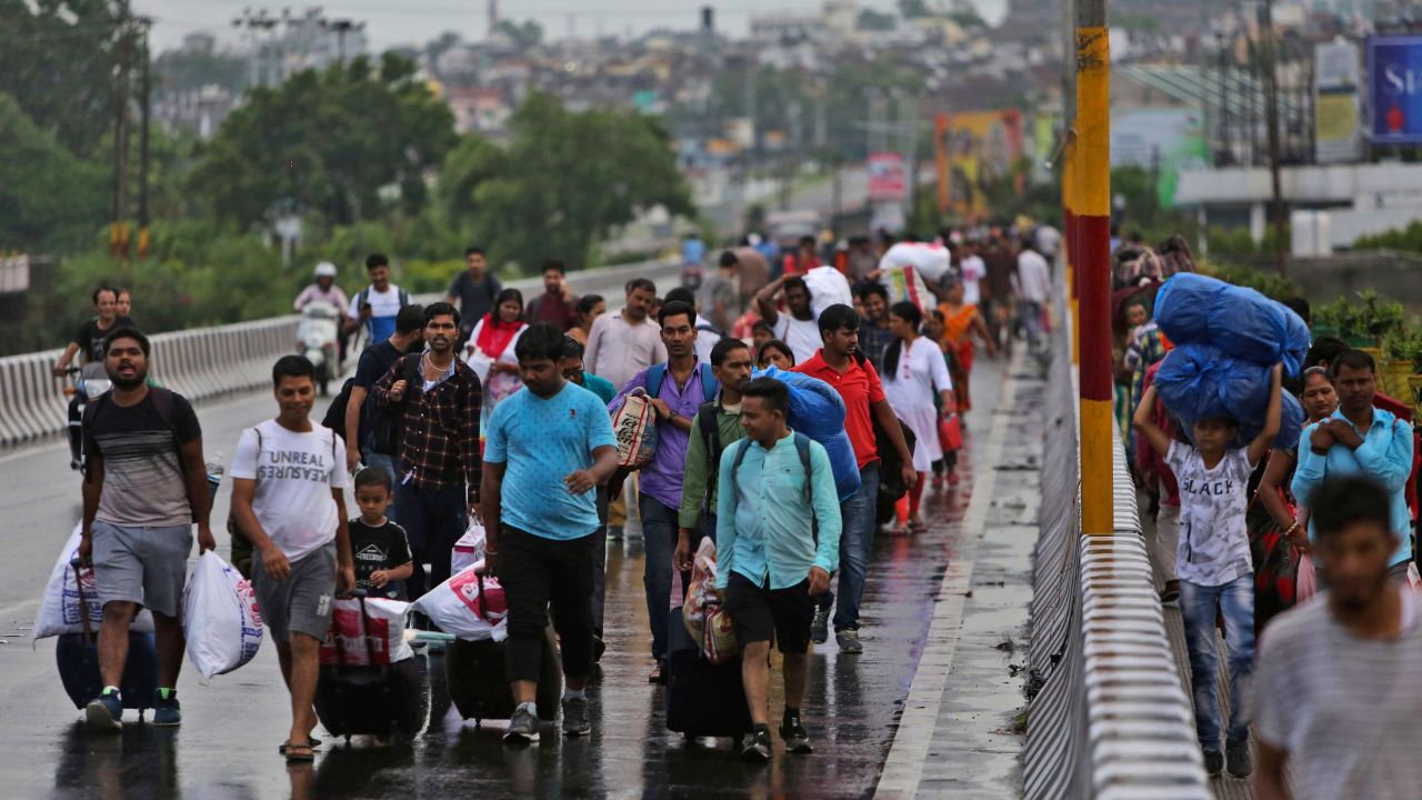 Stranded Indian tourists walk to a railway station during restrictions in Jammu on August 5, 2019.