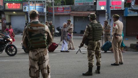 Tourists walk past Indian security forces in Jammu, India, on August 5, 2019.