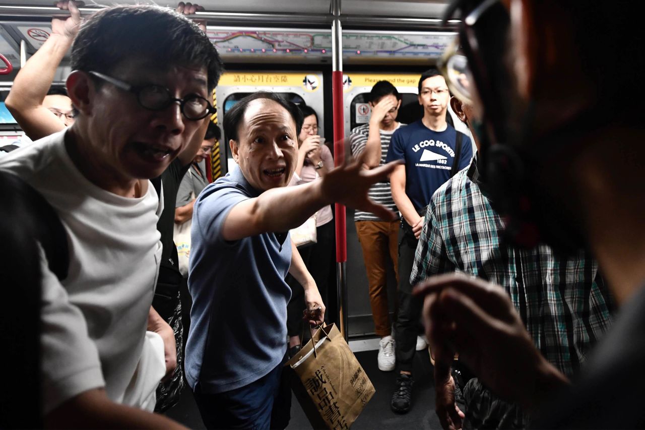 A train passenger gestures toward a protester, right, who was preventing the doors of a train from closing on August 5. The protester was trying to disrupt Hong Kong's morning rush-hour commute.