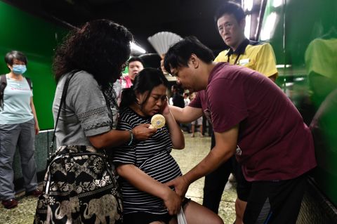 A man comforts his pregnant wife near a train platform after protesters blocked the train doors on August 5.
