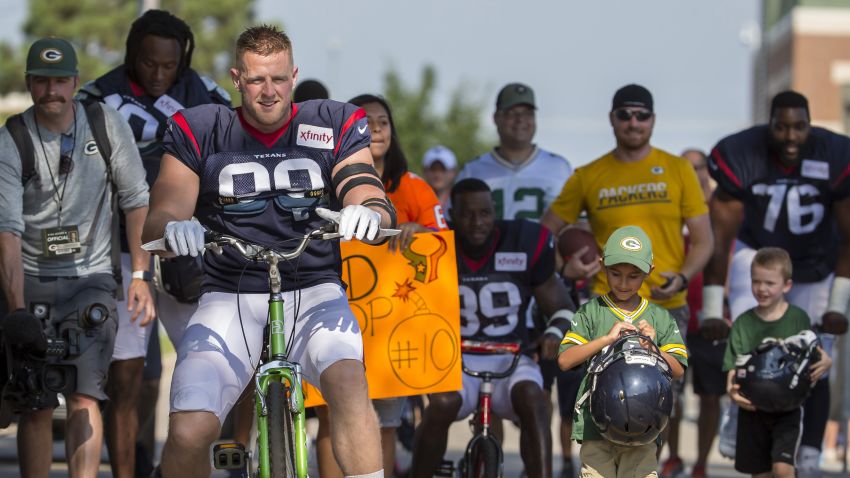 Houston Texans' J.J. Watt rides a bike to a joint NFL football practice between the Texans and the Green Bay Packers Monday, Aug 5, 2019, in Green Bay, Wis. (AP Photo/Mike Roemer)
