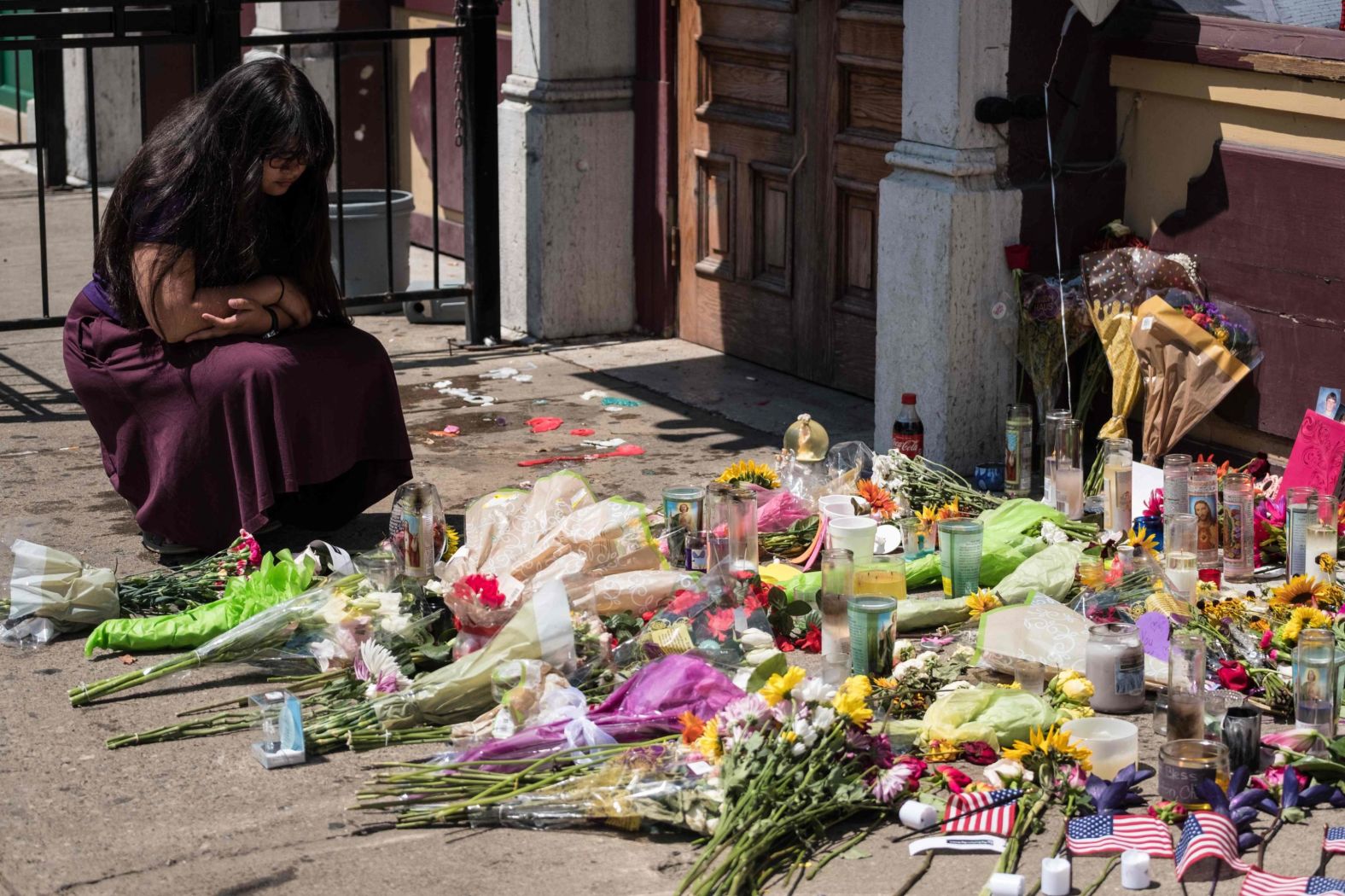 A woman kneels Monday at a memorial in Dayton.