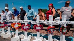People pray beside crosses with the names of victims who died in the shooting to a makeshift memorial after the shooting that left 22 people dead at the Cielo Vista Mall WalMart in El Paso, Texas, on August 5, 2019. - US President Donald Trump on Monday urged Republicans and Democrats to agree on tighter gun control and suggested legislation could be linked to immigration reform after two shootings left 30 people dead and sparked accusations that his rhetoric was part of the problem. "Republicans and Democrats must come together and get strong background checks, perhaps marrying this legislation with desperately needed immigration reform," Trump tweeted as he prepared to address the nation on two weekend shootings in Texas and Ohio. "We must have something good, if not GREAT, come out of these two tragic events!" Trump wrote. (Photo by Mark RALSTON / AFP)        (Photo credit should read MARK RALSTON/AFP/Getty Images)