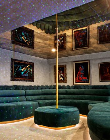 A party room featuring disco lights, carpeted walls, a mirrored ceiling and pole-dancing facilities.