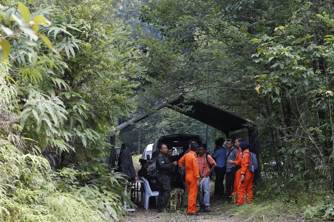 Members of search and rescue teams work at a temporary operation shelter near to The Dusun resort on Tuesday.
