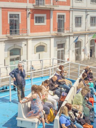 "This is the top of the boat from the previous image. The buildings belong to Naples and these are the tourists and locals looking to make that commute over to Procida."