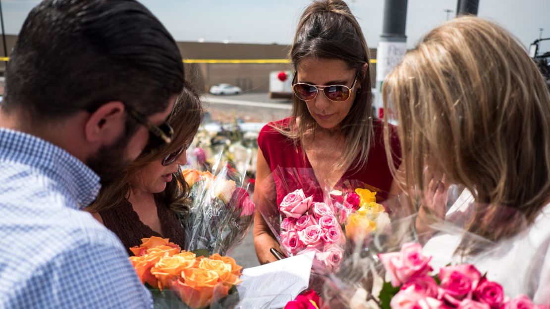 Claudia Portillo, 52, second from right, prays Tuesday near the site of the Walmart shooting.