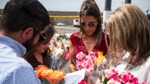 Claudia Portillo, 52, second from right, prays Tuesday near the site of the Walmart shooting.