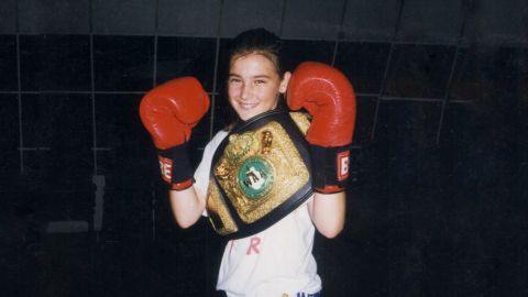 Katie Taylor with boxing gloves and a belt.