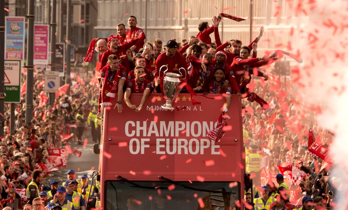 Liverpool coach Jurgen Klopp (C) holds the Champions League trophy as he stands with his players during an open-top bus parade around the city.
