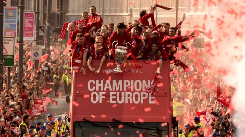 Liverpool coach Jurgen Klopp (C) holds the Champions League trophy as he stands with his players during an open-top bus parade around the city.