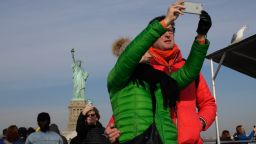 Tourist take pictures as the cruise goes around the Statue of Liberty on January 21, 2018 in New York City.