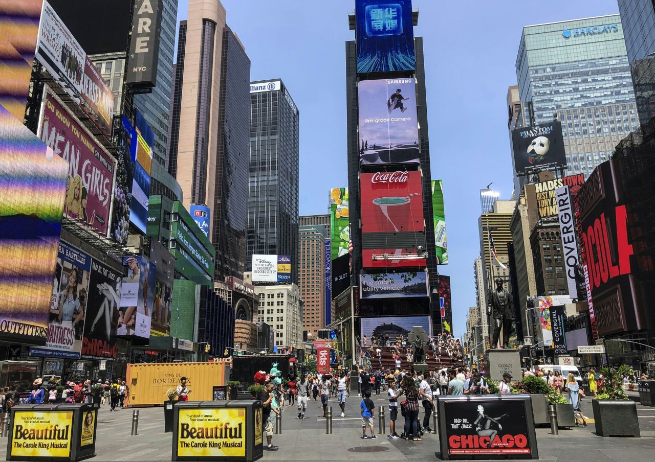 People walk around Times Square in New York City on July 9, 2019. 