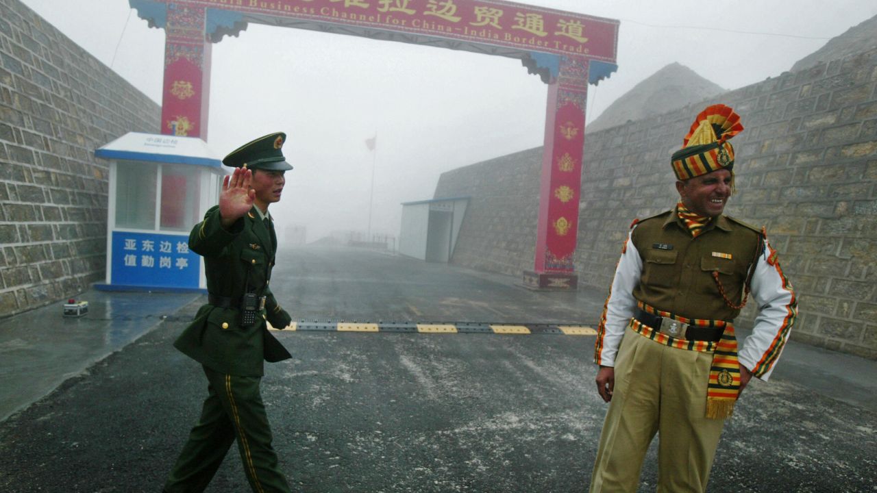 Guards stand at the India-China border. India's leaders may look to China's policies in Xinjiang and Tibet to control Kashmir. 