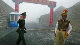 TO GO WITH STORY BY PARUL GUPTA 'INDIA-CHINA-DIPLOMACY-TRADE'  In this photograph taken on July 10, 2008 a Chinese soldier (L) and an Indian soldier stand guard at the Chinese side of the ancient Nathu La border crossing between India and China.  When the two Asian giants opened the 4,500-metre-high (15,000 feet) pass in 2006 to improve ties dogged by a bitter war in 1962 that saw the route closed for 44 years, many on both sides hoped it would boost trade. Two years on, optimism has given way to despair as the flow of traders has shrunk to a trickle because of red tape, poor facilities and sub-standard roads in India's remote northeastern mountainous state of Sikkim.  AFP PHOTO/Diptendu DUTTA (Photo credit should read DIPTENDU DUTTA/AFP/Getty Images)