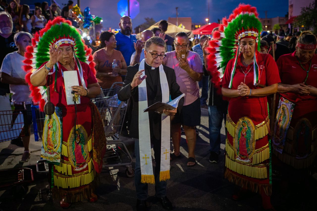Members of the Apache tribe stand alongside a priest during a vigil in El Paso.