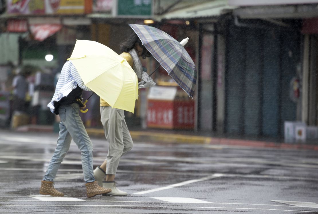 Two Taiwanese women face powerful gusts of wind generated by Typhoon Lekima in Taipei, Taiwan, on August 9, 2019. 