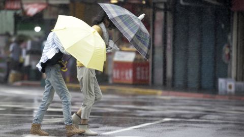 Two Taiwanese women face powerful gusts of wind generated by Typhoon Lekima in Taipei, Taiwan, on August 9, 2019.
